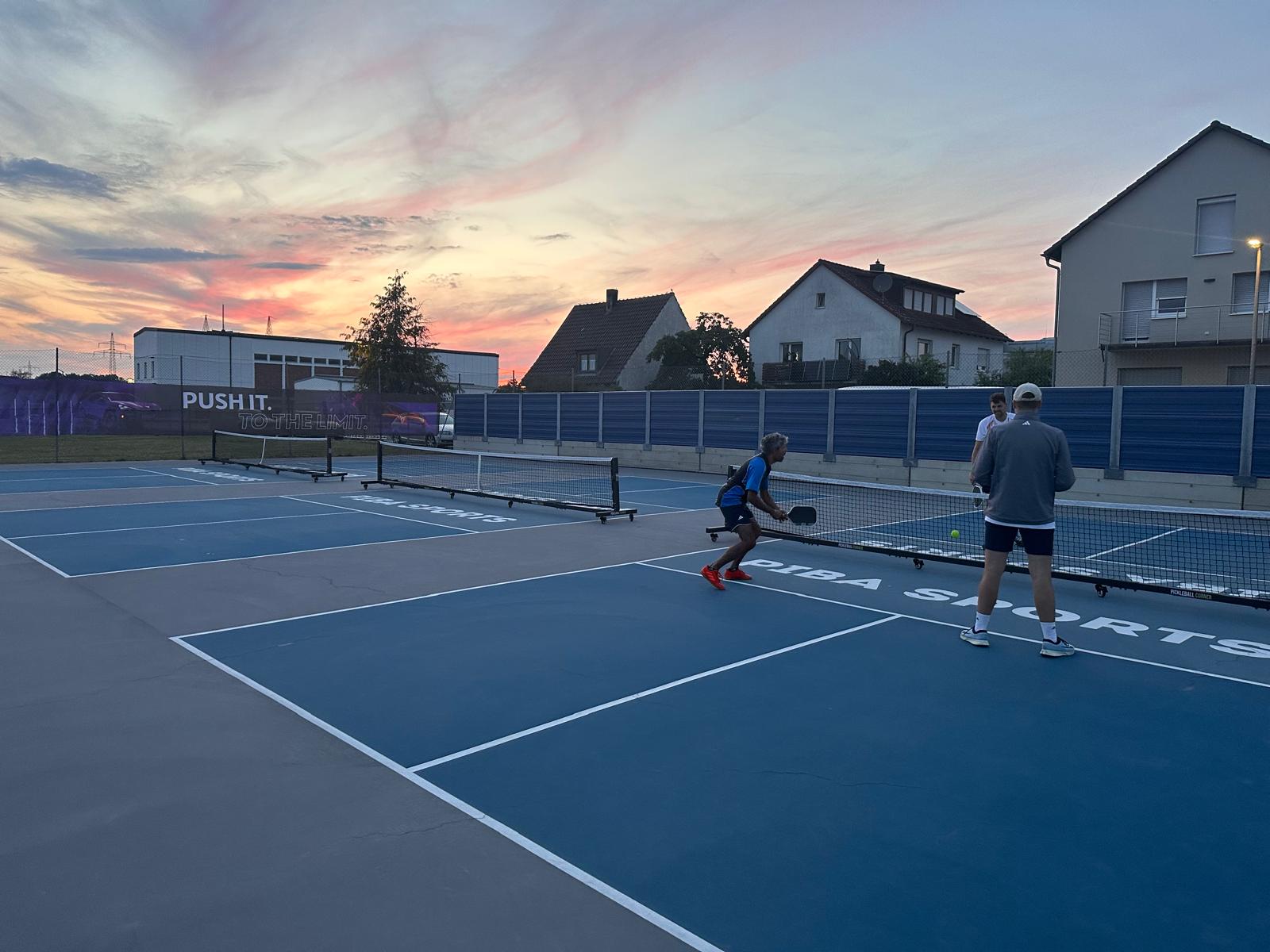 Pickleball-Doppel auf den Outdoor-Courts von PIBA Neumarkt bei Sonnenuntergang